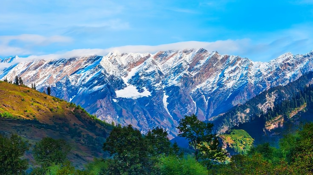Snow-covered Himalayan peaks above a green Kashmir valley