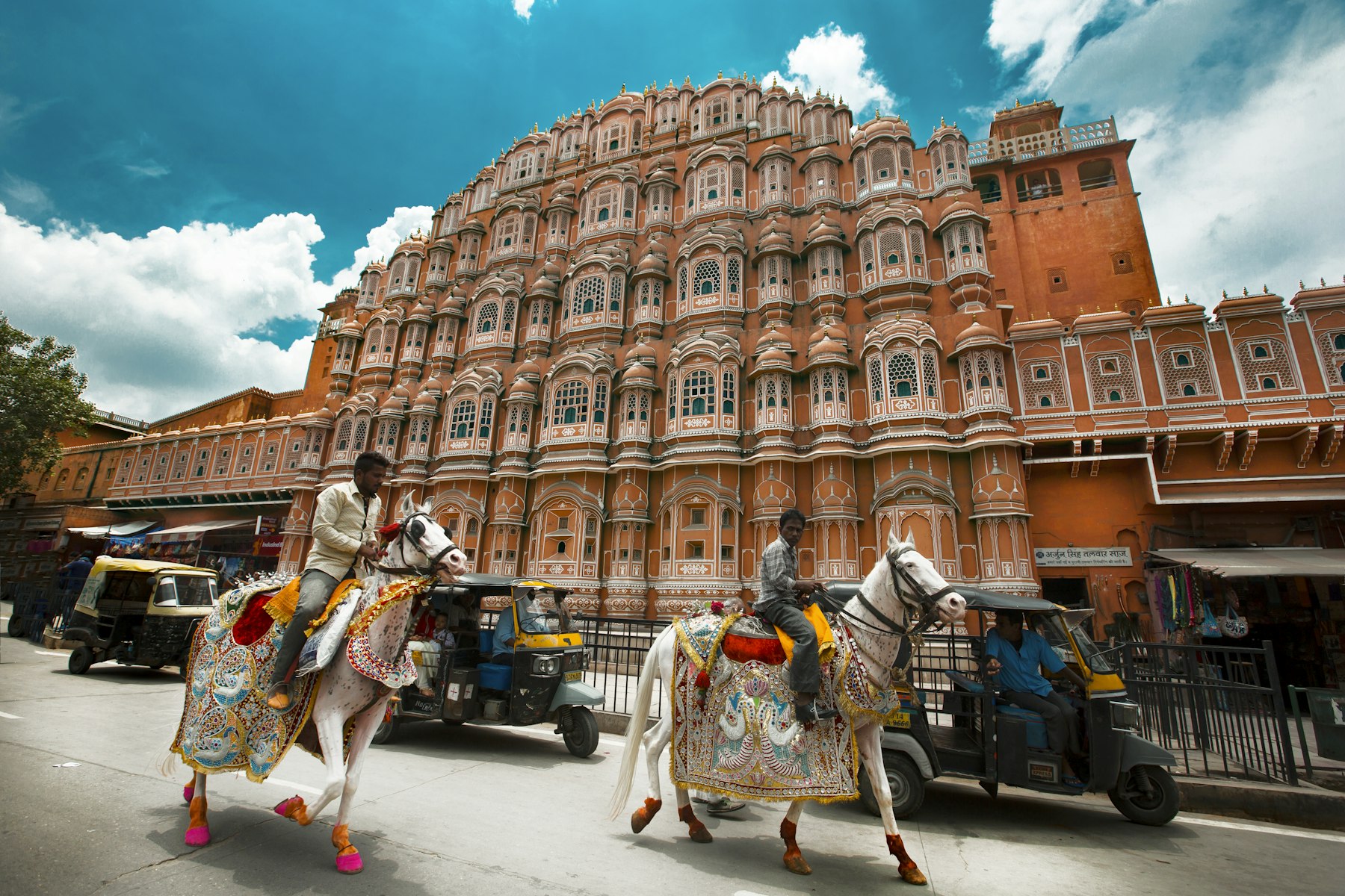 Hawa Mahal and riders on decorated horses in Jaipur