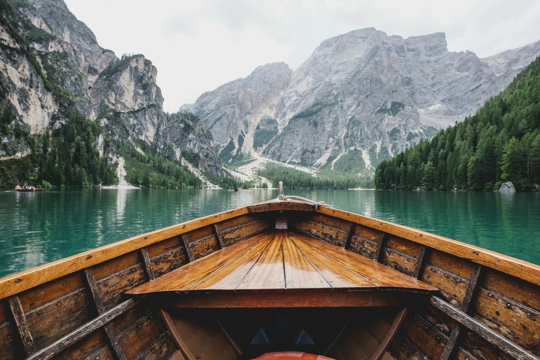 A wooden boat heading into a mountain lake